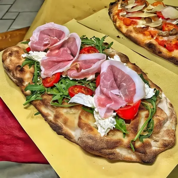 A flatbread with rocket, cherry tomatoes, mozzarella and prosciutto